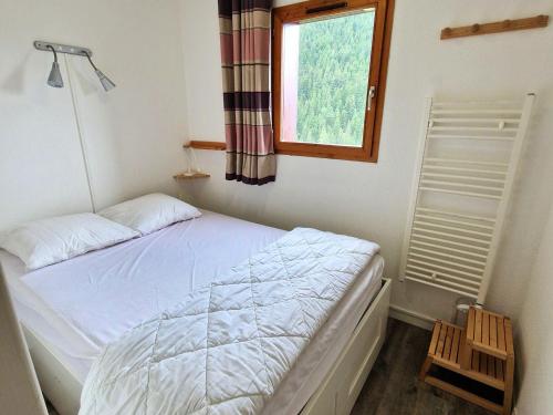 une petite chambre avec un lit et une fenêtre dans l'établissement Appartement spacieux 8 pers, cœur de Valfréjus - FR-1-265-351, à Modane