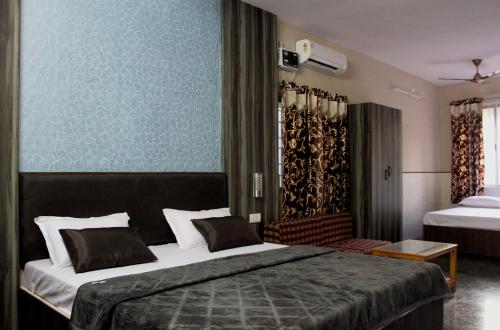 una camera con un grande letto e una parete blu di Vinodhara Guest House a Mamallapuram