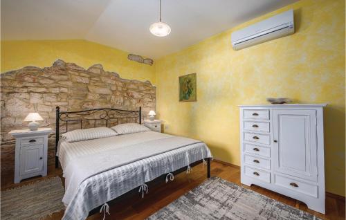 a bedroom with a bed and a stone wall at Holiday Home Butkovici Croatia in Butkovići