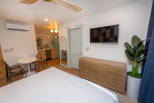 a bedroom with a bed and a table and a tv at The Boardwalk Hotel in San Diego