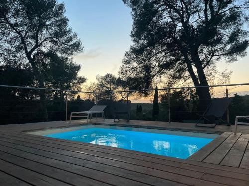- une piscine avec une terrasse en bois dans l'établissement Lou Mazet - Nîmes, à Nîmes