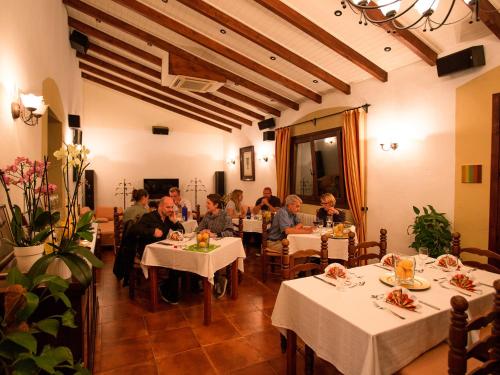 a group of people sitting at tables in a restaurant at Finca Hotel Rural Predio Son Serra in Can Picafort