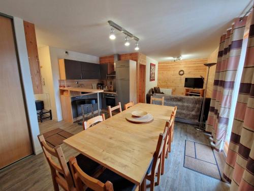 une cuisine et une salle à manger avec une table et des chaises en bois dans l'établissement Appartement spacieux 8 pers, cœur de Valfréjus - FR-1-265-351, à Modane