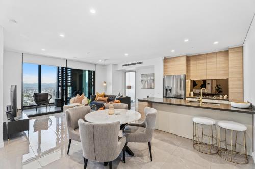 a kitchen and living room with a table and chairs at Ocean Surfers Paradise - gclr in Gold Coast