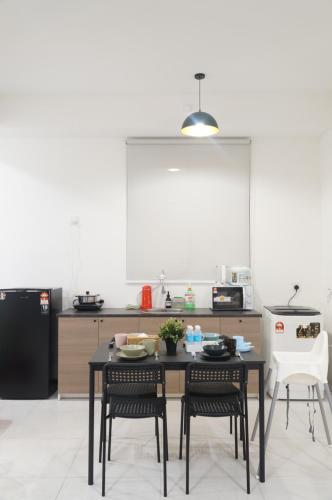 a kitchen with a table and chairs in a kitchen at Urban Suites Infinity Pool 3BR 2Carparks 8pax in Jelutong