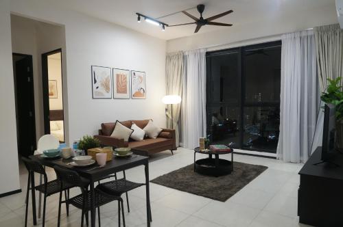 a living room with a couch and a table at Urban Suites Infinity Pool 3BR 2Carparks 8pax in Jelutong
