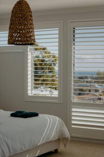 a bedroom with a bed and a window with blinds at Above The Clouds by St Nicholas in Perth