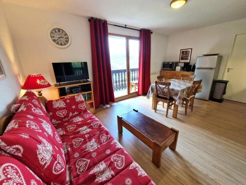 un salon avec un canapé rouge et une table dans l'établissement Apt 6/8 pers, 2 pièces, cabine, cœur de Valfréjus, WiFi, animaux admis - FR-1-265-354, à Modane