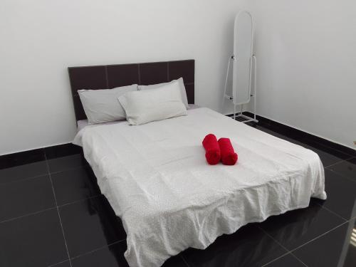 un paio di scarpe rosse appoggiate su un letto di Islam Taqwa Homestay a Kuala Lipis