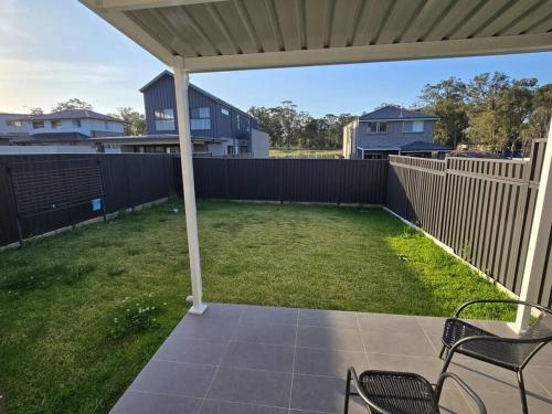 a patio with two chairs and a fence at Luxury 5 Bedrooms 3 full Bathrooms home in centre of Rouse Hill in Riverstone