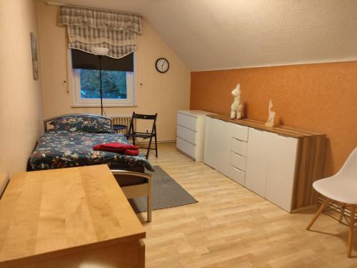 Un pequeño dormitorio con una cama y una mesa. en Wohnung am Stadtrand, en Lemgo