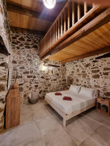 a bedroom with a bed in a stone wall at Mesavlia Traditional Stone House in Mesávlia