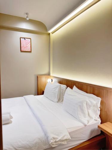 a bedroom with a bed with white sheets and pillows at Urban room samed in Ko Samed