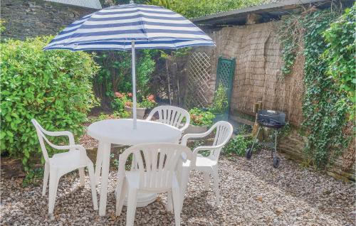 une table et des chaises avec un parasol et un grill dans l'établissement Pet Friendly Home In Ruffiac With Wifi, à Ruffiac