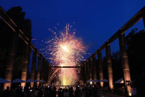 a firework exploding over a bridge at night at Yangshuo Sugar House in Yangshuo