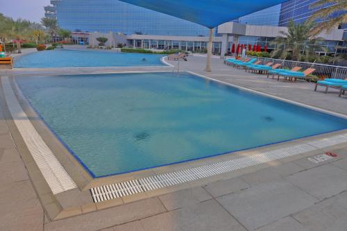a large swimming pool with blue water in a building at The Art Hotel & Resort in Manama