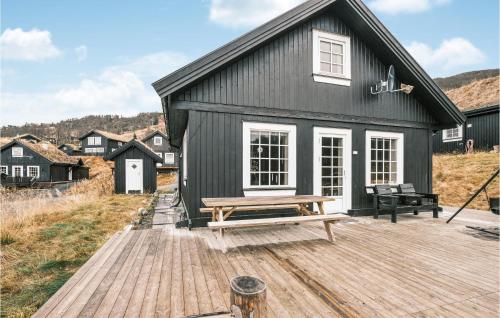 una casa negra con un banco en una terraza de madera en Stunning Home In Rauland With Wifi, en Rauland