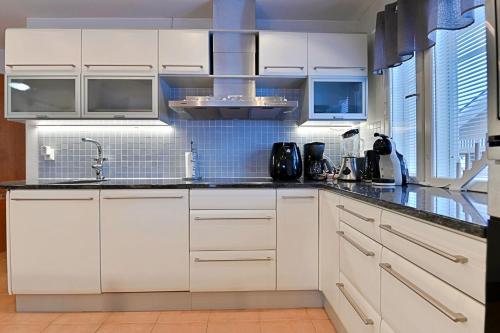 a kitchen with white cabinets and black counter tops at Central Alley 3B - including linen and towels in Levi