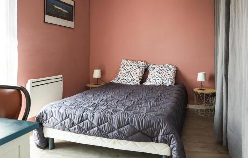 a bedroom with a bed in a red wall at Nice Home In Clohars-Carnoët With Wifi in Clohars-Carnoët