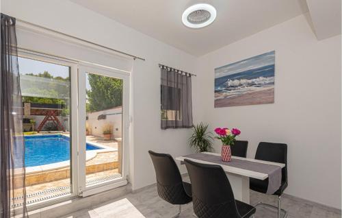 comedor con mesa, sillas y piscina en Nice Apartment In Dubrava Kod Sibenika, en Dubrava
