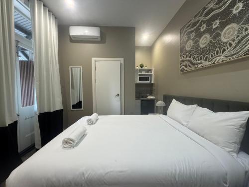 a bedroom with a large white bed and a window at K2 Brisbane in Brisbane