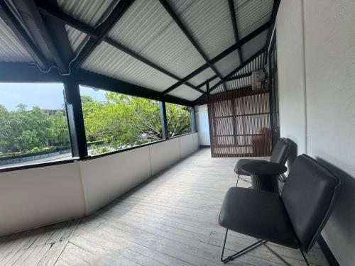 a room with two chairs and a table and windows at K2 Brisbane in Brisbane