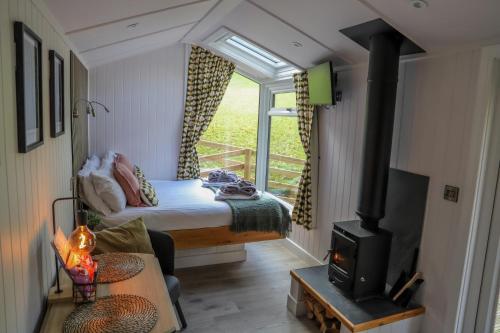a bedroom with a bed and a stove in a room at Ty Nant Gwenyn in Llanymawddwy