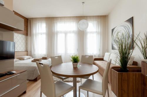 un salon avec une table et des chaises et une chambre dans l'établissement Holidays Concept, à Budapest