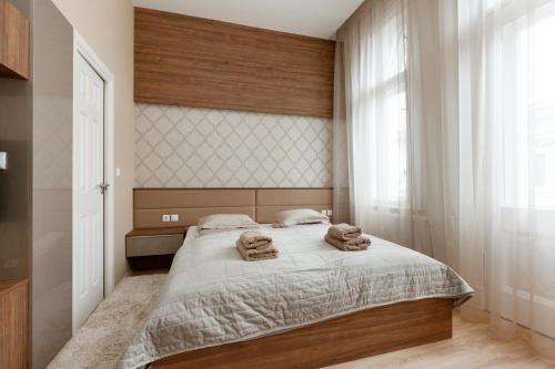 een slaapkamer met een bed waarop twee handdoeken liggen bij Holidays Concept in Boedapest
