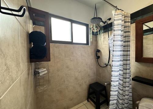 a bathroom with a shower and a window at Designer-inspired 1bed1bath Condo Close To Beach in Coco