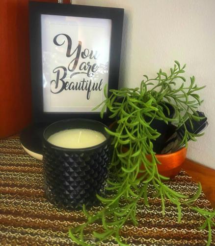 a table with a candle and a plant and a sign at Designer-inspired 1bed1bath Condo Close To Beach in Coco