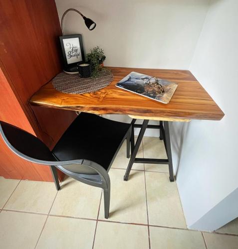 a wooden table with a lamp and a desk with a chair at Designer-inspired 1bed1bath Condo Close To Beach in Coco