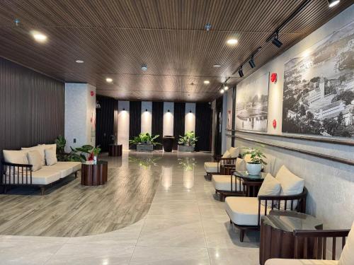 a lobby with chairs and tables in a building at Nature Hotel - Win Happy in Da Lat