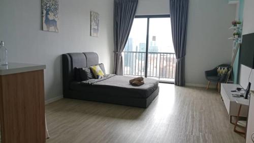 a living room with a bed and a large window at Chambers Residence by Gloria Homes in Kuala Lumpur