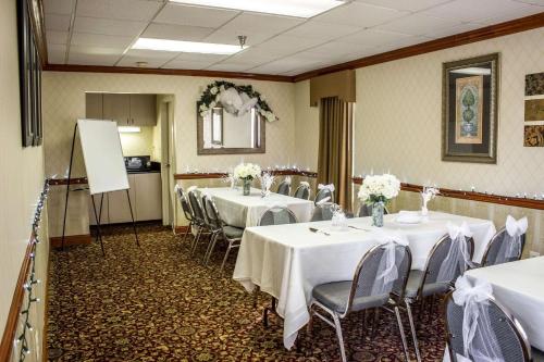 a conference room with tables and chairs with white tablecloths at Clarion Pointe Research Triangle Park Durham in Durham