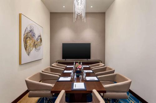a conference room with a long table and chairs at Wyndham Grand Doha West Bay Beach in Doha
