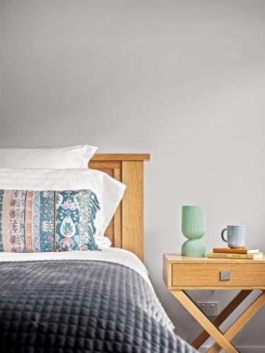 a bedroom with a bed and a table with a night stand at Reubs - Margaret River in Margaret River Town