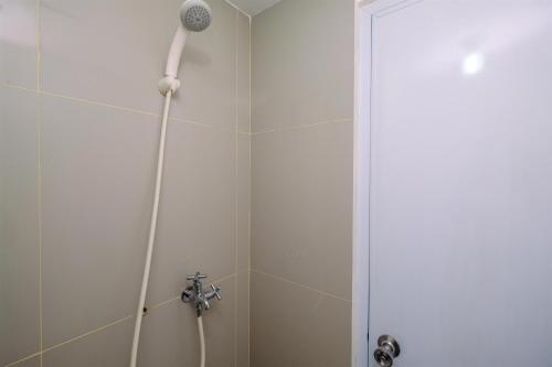 a shower with a shower head in a bathroom at Homey Studio at Bogorienze Apartment near The Jungle Waterpark By Travelio in Pamoyanan