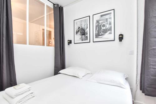 - une chambre blanche avec 2 oreillers blancs sur un lit dans l'établissement Peaceful apartment - 2BR for 4P - Musee Grevin, à Paris