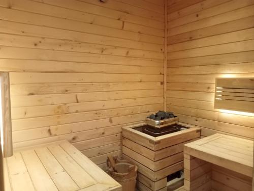 a wooden sauna with a stove in it at Spacious and Elegant 3BR Loft at Kingland Avenue Apartment By Travelio in Tangerang