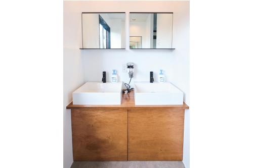 a bathroom with two sinks and a mirror at J-Hoppers Lake Biwa Guesthouse in Otsu