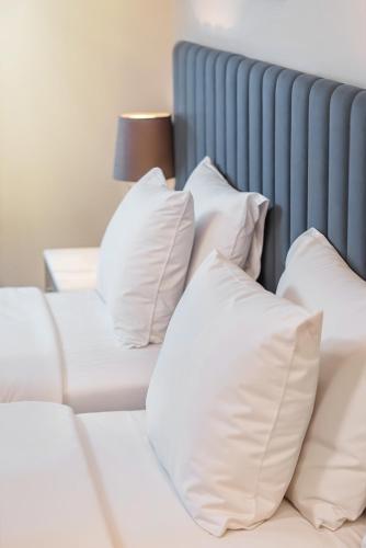 a bed with white pillows and a blue headboard at King Gorgasali in Tbilisi City