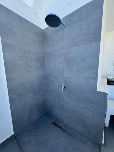 a bathroom with a shower with a stone wall at Esentepede 2yatak odalı Penthouse Daire Cove I8 in Khóti Nisí