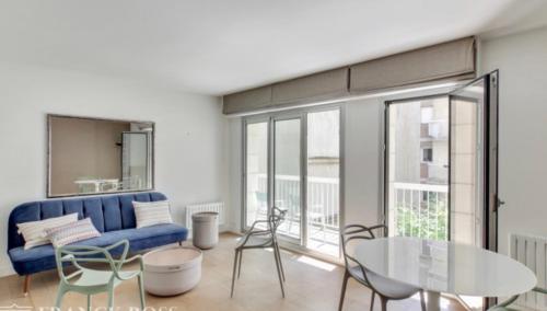 un salon avec un canapé bleu, une table et des chaises dans l'établissement Another Attractive Flat near by St-Germain, St-Placide, à Paris