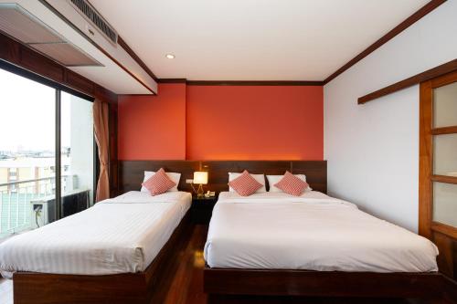 Una cama o camas en una habitación de The President Hotel at Chokchai 4