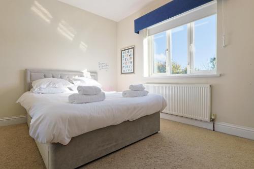 Un dormitorio con una cama grande con toallas. en "Rosecroft" - Perfect Retreat for Business & Leisure - Close to Celtic Manor and ICC, en Newport