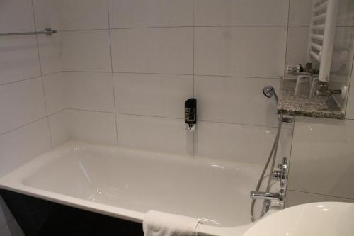 a bath tub in a bathroom with a shower at Hotel Weidenhof in Düsseldorf