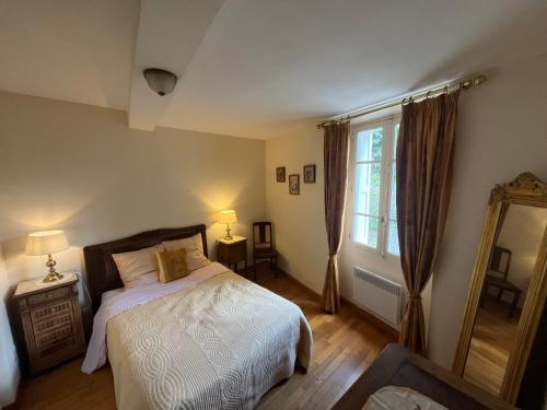 une chambre avec un lit et une grande fenêtre dans l'établissement Maison de village, à Saint-Hilaire