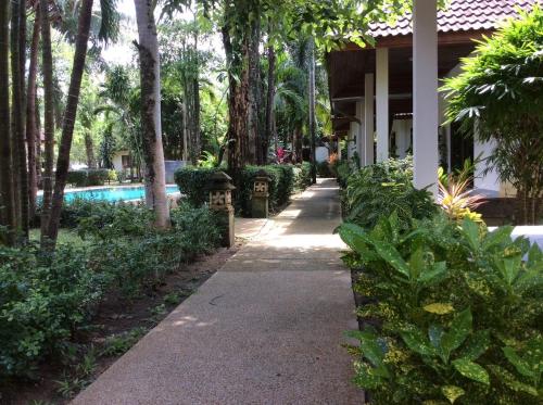 a walkway in front of a house with a pool at Cousin Resort in Khao Lak