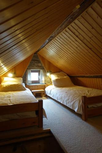 - une chambre mansardée avec 2 lits et une fenêtre dans l'établissement Petit chalet de montagne, à Mizoën